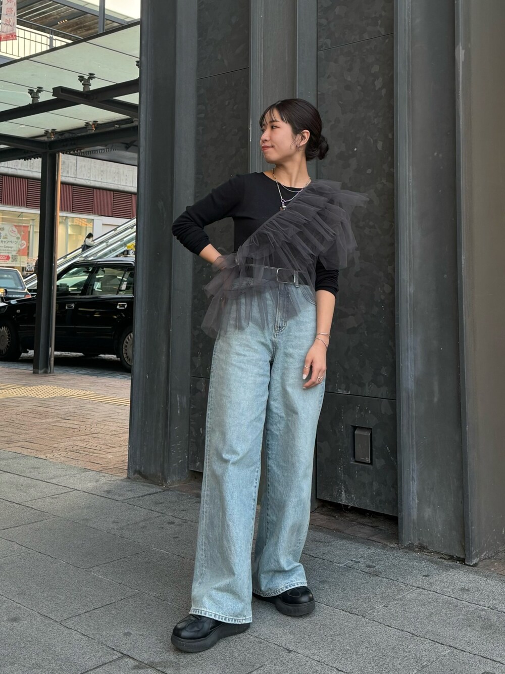グレー系のベスト、ブラック系のTシャツ/カットソー、ブルー系のデニムパンツを着用したレディースの冬コーディネートの1枚目の写真