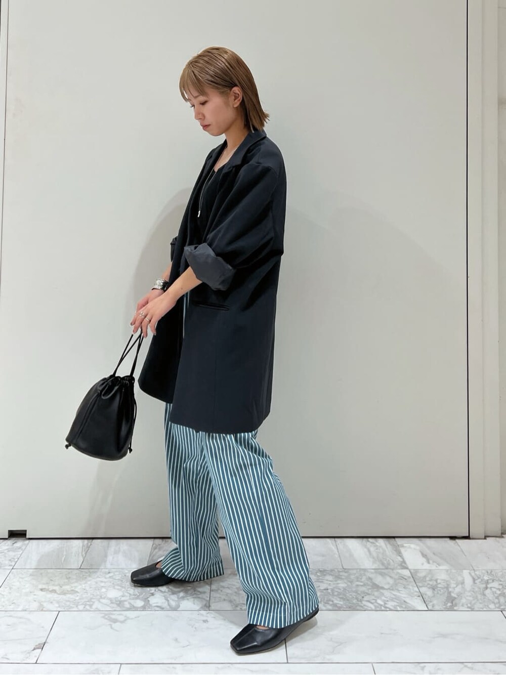 グリーン系のその他パンツ、ブラック系のハンドバッグ、グレー系のテーラードジャケットを着用したレディースの夏コーディネートの1枚目の写真