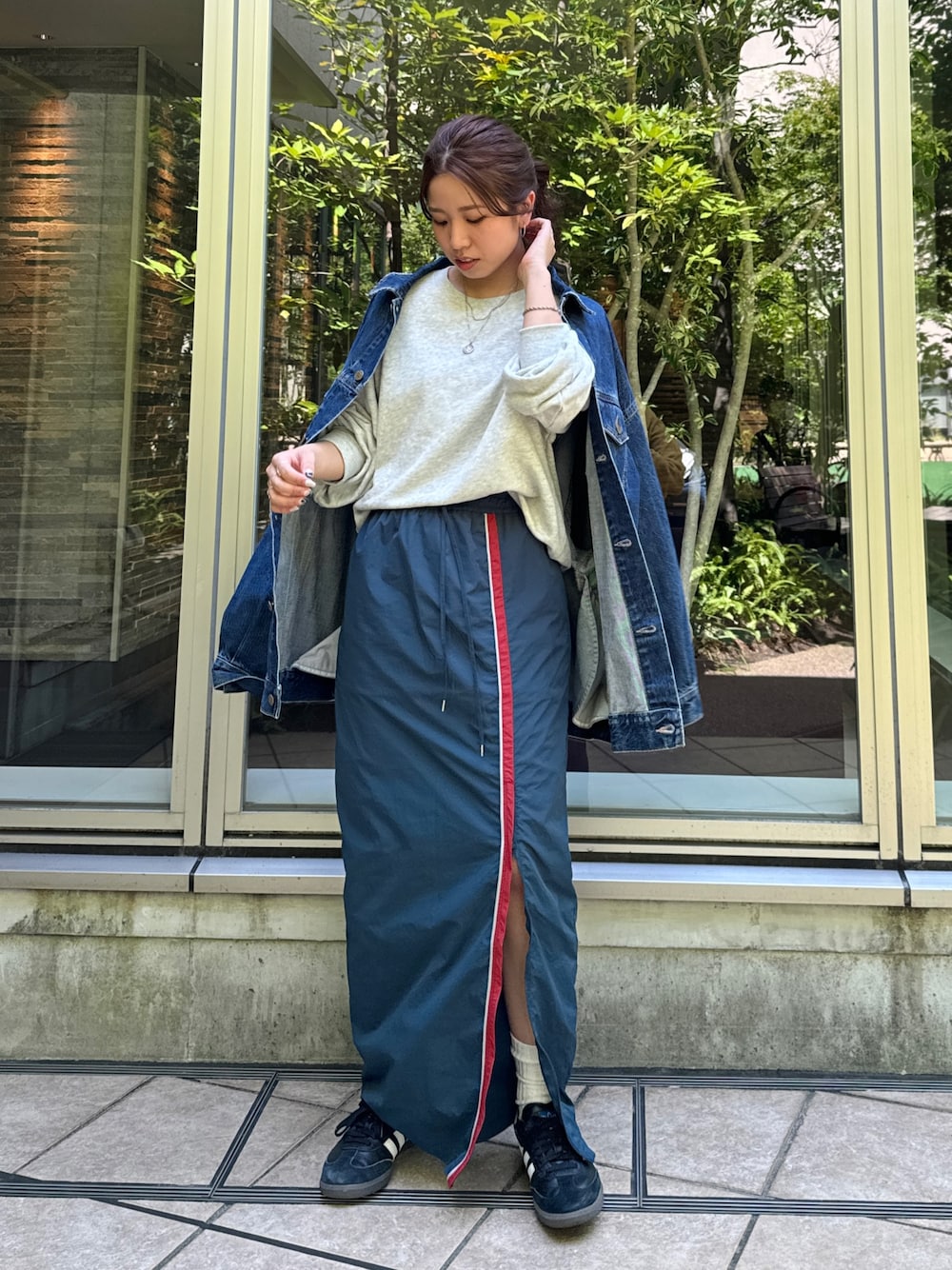 ブルー系のスカート、グレー系のスウェット、ブルー系のデニムジャケットを着用したレディースの夏コーディネートの1枚目の写真