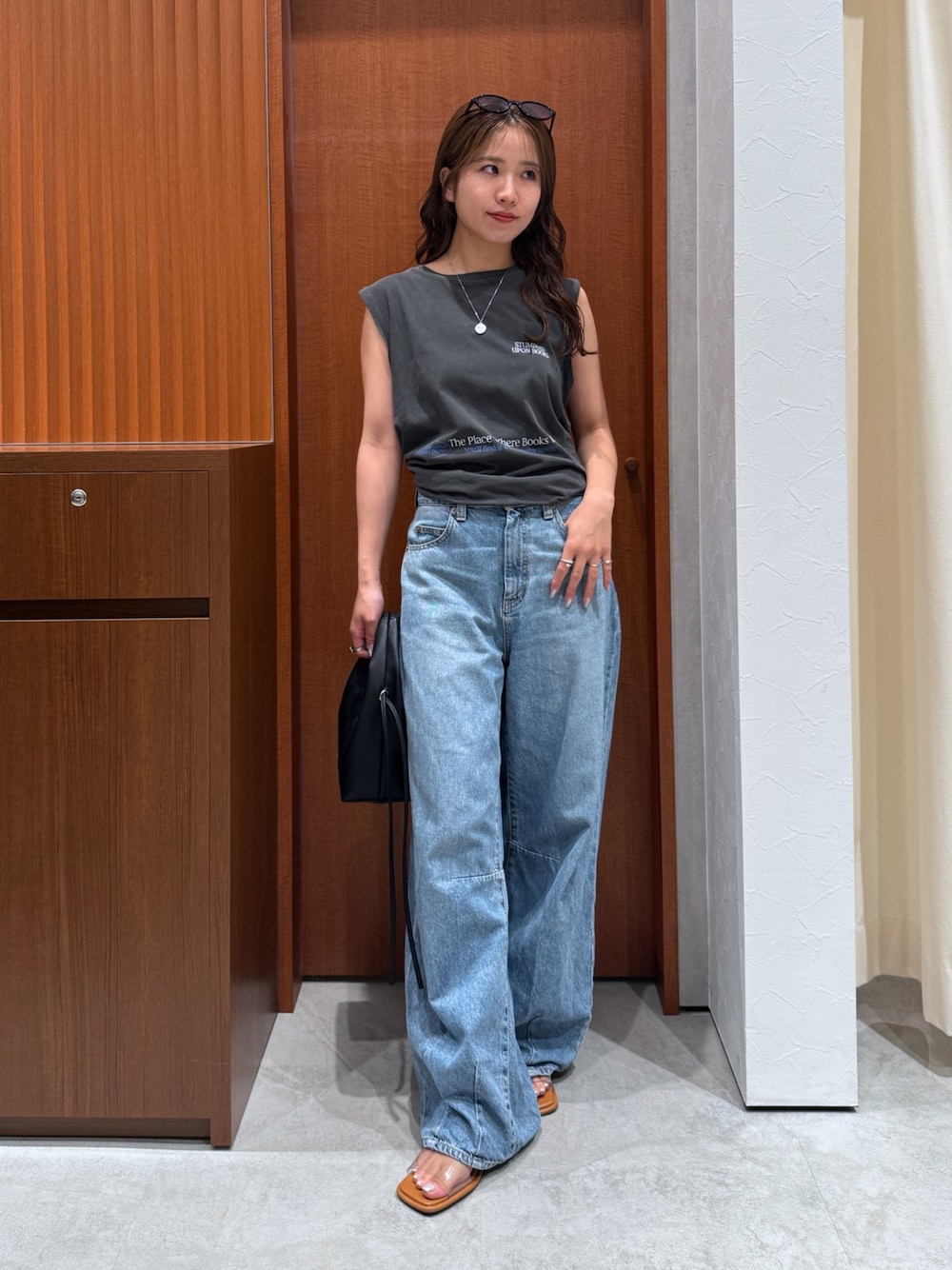 グレー系のタンクトップ、ブルー系のデニムパンツ、その他のサンダルを着用したレディースの夏コーディネートの1枚目の写真