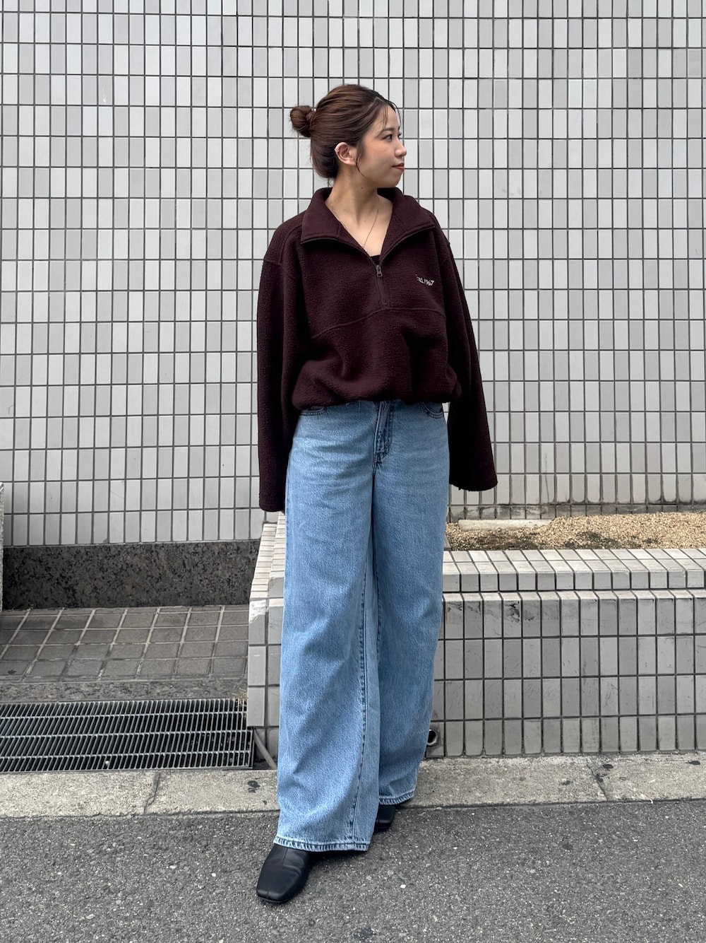ブラウン系のパーカー、ブルー系のデニムパンツ、ブラック系のサンダルを着用したレディースの秋コーディネートの1枚目の写真
