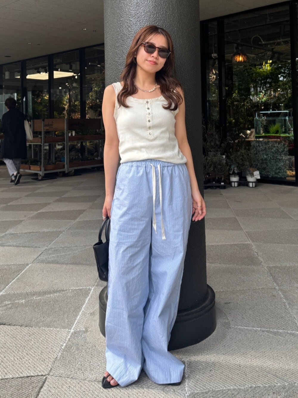 ブルー系のその他パンツ、ホワイト系のタンクトップを着用したレディースの春コーディネートの1枚目の写真