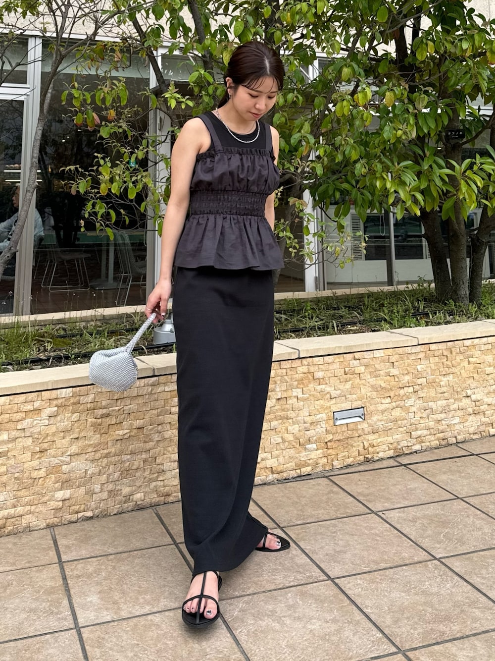 ブラック系のワンピース、グレー系のキャミソール、シルバー系のハンドバッグを着用したレディースの春コーディネートの1枚目の写真