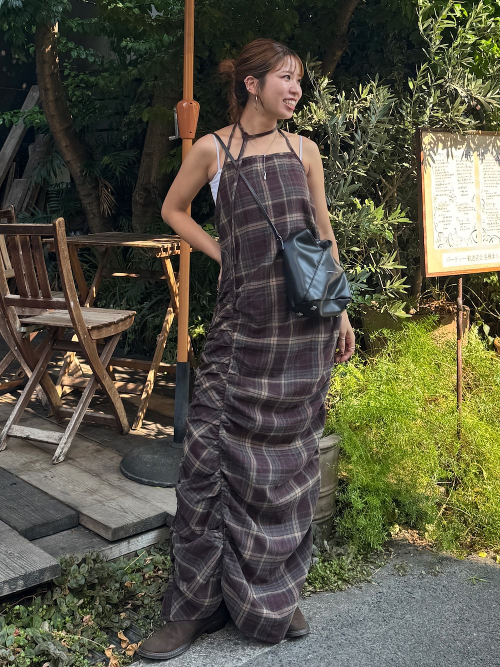 レッド系のワンピース、ブラウン系のブーツを着用したレディースの秋コーディネートの1枚目の写真