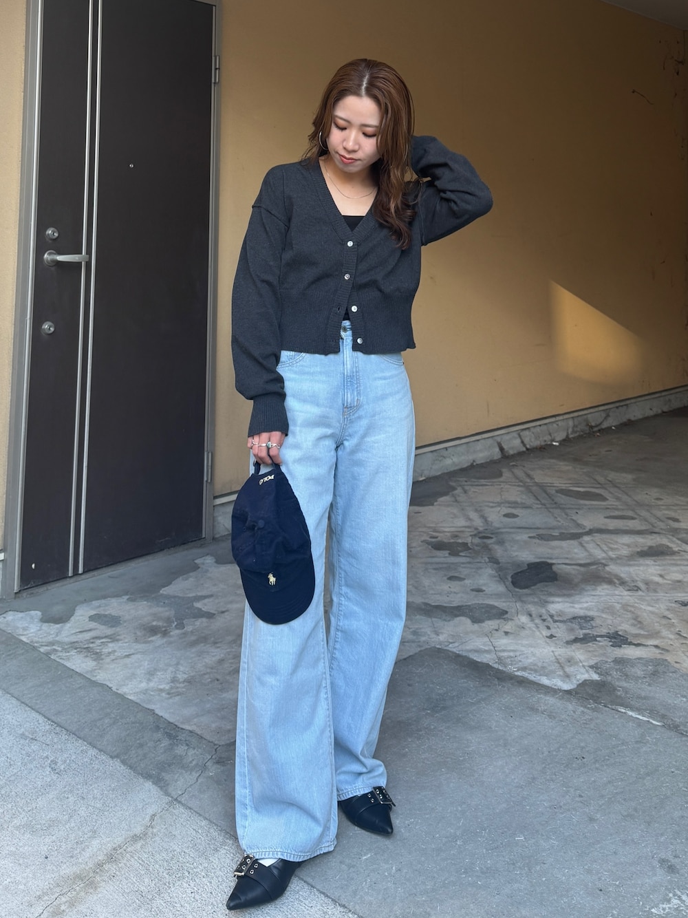 グレー系のカーディガン/ボレロ、ブルー系のデニムパンツを着用したレディースの春コーディネートの1枚目の写真