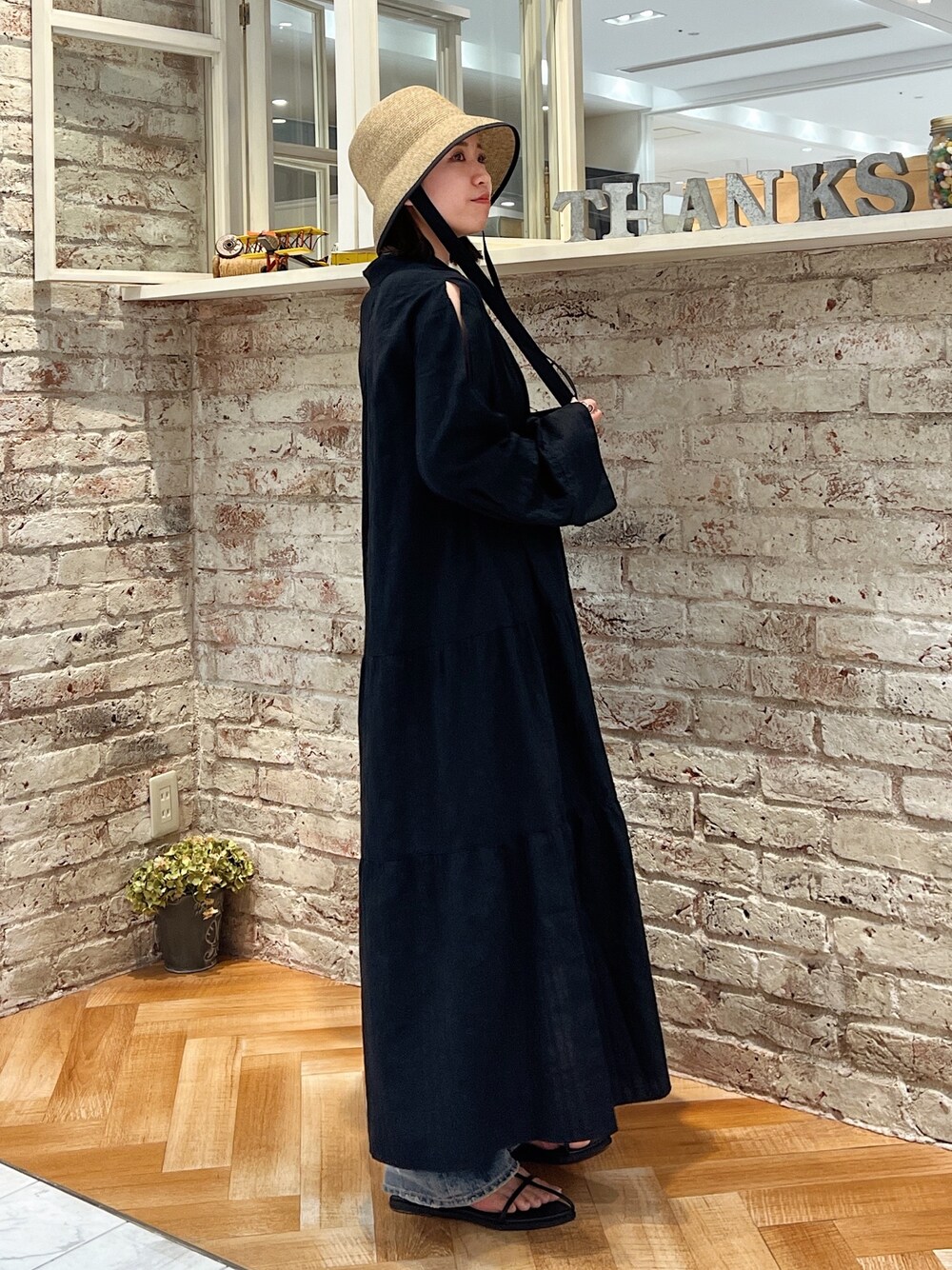 ブルー系のデニムパンツ、ブラック系のサンダル、ブラック系のワンピースを着用したレディースの春コーディネートの1枚目の写真
