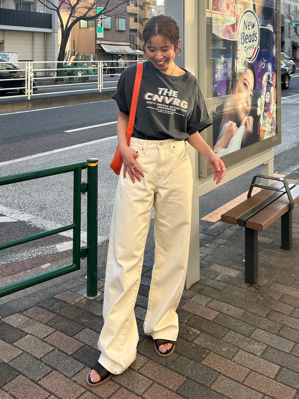 グレー系のTシャツ/カットソー、ホワイト系のデニムパンツ、オレンジ系のショルダーバッグを着用したレディースの春コーディネートの1枚目の写真