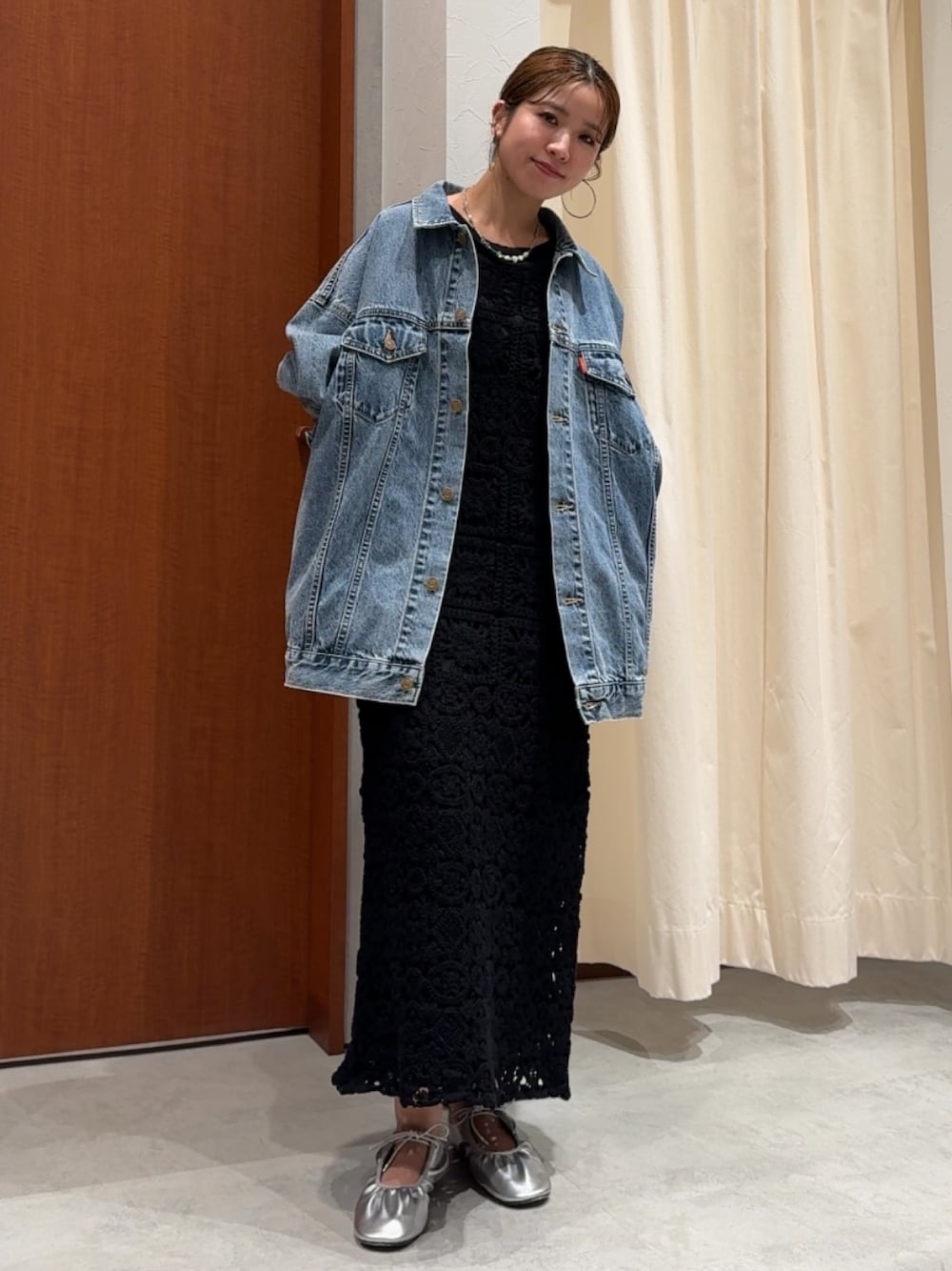 ブラック系のワンピース、ブラック系のTシャツ/カットソー、ブルー系のデニムジャケットを着用したレディースの春コーディネートの1枚目の写真