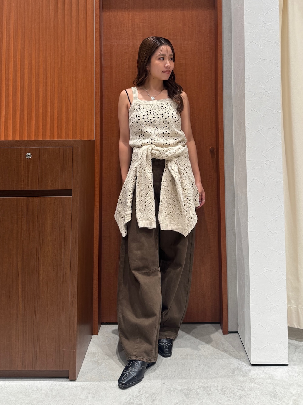 ブラウン系のデニムパンツ、ホワイト系のアンサンブル、ブラック系のその他シューズを着用したレディースの秋コーディネートの1枚目の写真