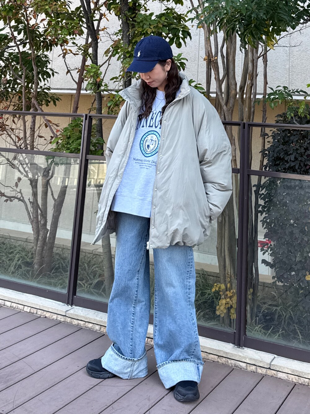 ベージュ系のブルゾン、グレー系のスウェット、ブルー系のデニムパンツを着用したレディースの冬コーディネートの1枚目の写真