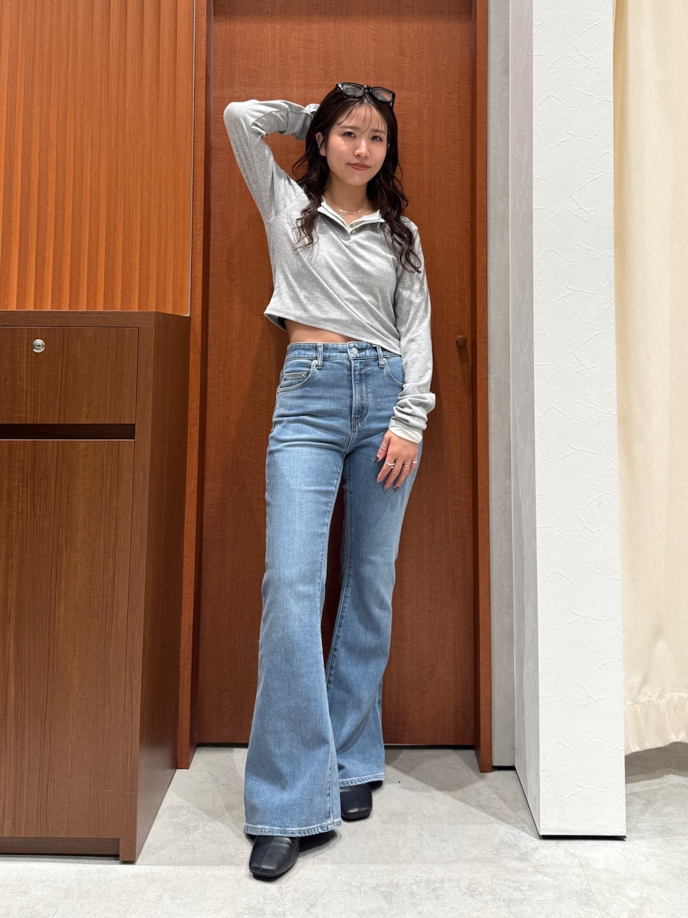 ブルー系のデニムパンツ、ブラック系のサンダル、グレー系のTシャツ/カットソーを着用したレディースの秋コーディネートの1枚目の写真
