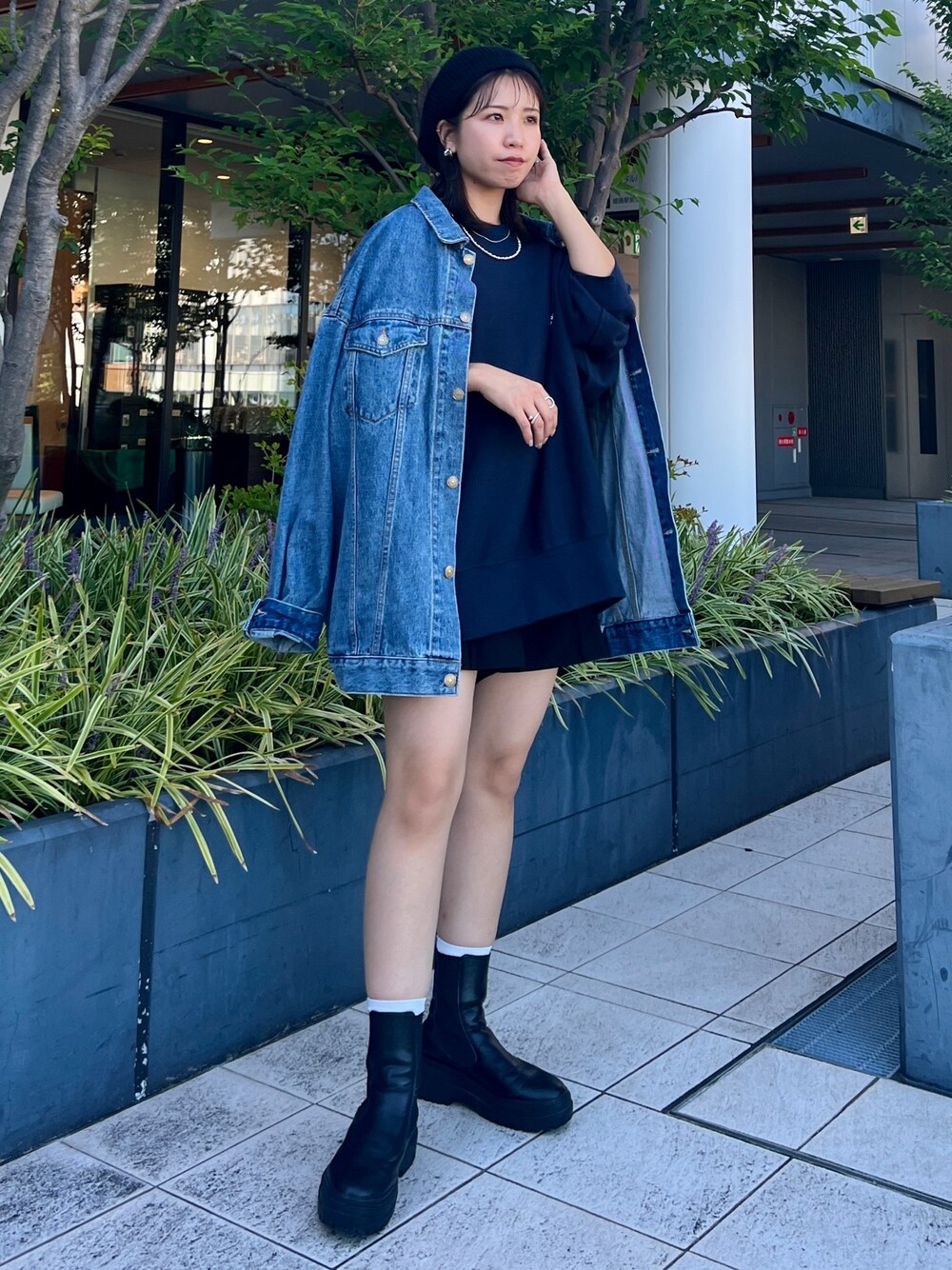 ブルー系のスウェット、ブルー系のデニムジャケット、ブラック系のハンチング/ベレー帽を着用したレディースの秋コーディネートの1枚目の写真