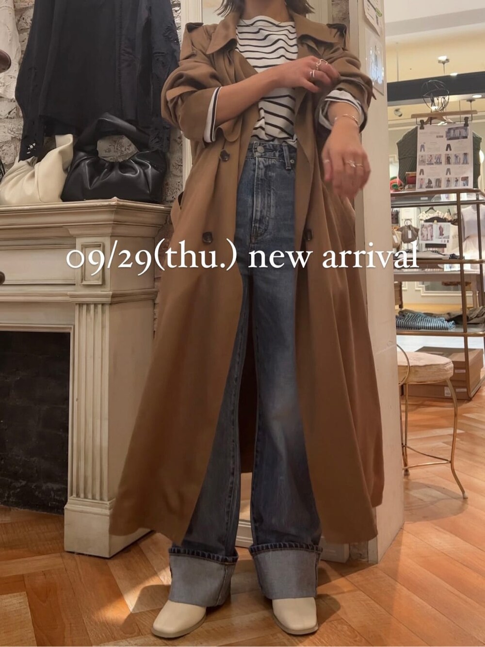 ブルー系のTシャツ/カットソー、イエロー系のトレンチコート、ホワイト系のブーツを着用したレディースの秋コーディネートの1枚目の写真