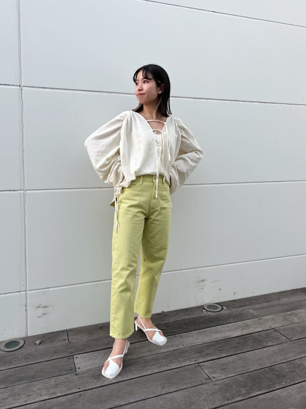 グリーン系のデニムパンツ、ホワイト系のシャツ/ブラウス、ホワイト系のサンダルを着用したレディースの春コーディネートの1枚目の写真