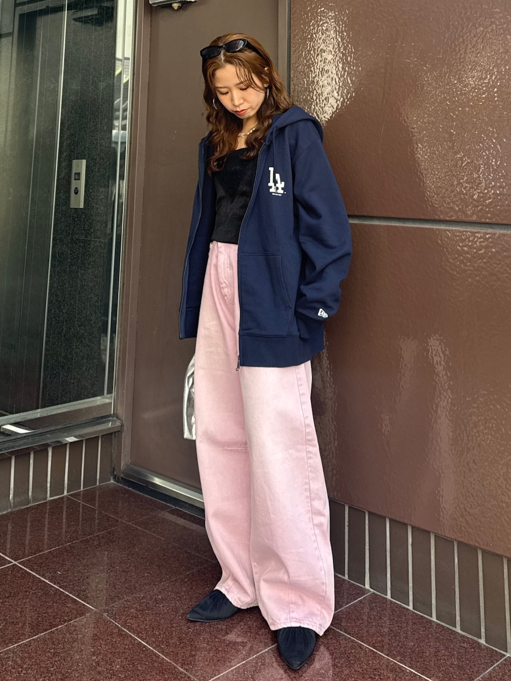 ブルー系のパーカー、ピンク系のデニムパンツ、ブラック系のキャミソールを着用したレディースの春コーディネートの1枚目の写真