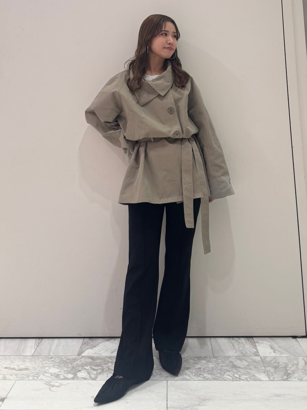 グリーン系のトレンチコート、ブラック系のその他パンツ、ブラック系のパンプスを着用したレディースの春コーディネートの1枚目の写真