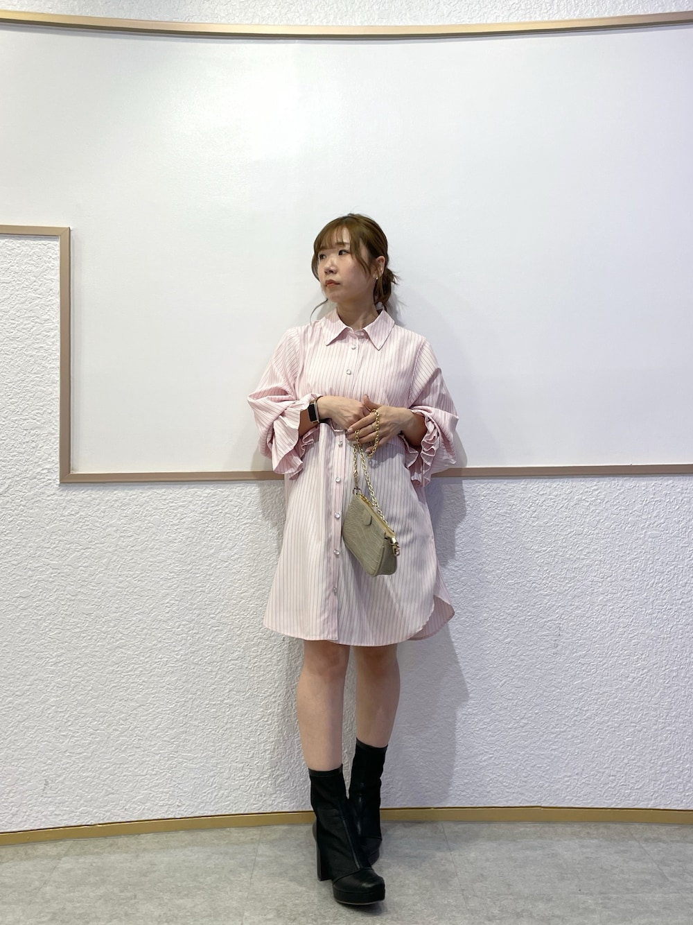 ピンク系のワンピース、ブラック系のブーツ、グレー系のスカートを着用したレディースの春コーディネートの1枚目の写真