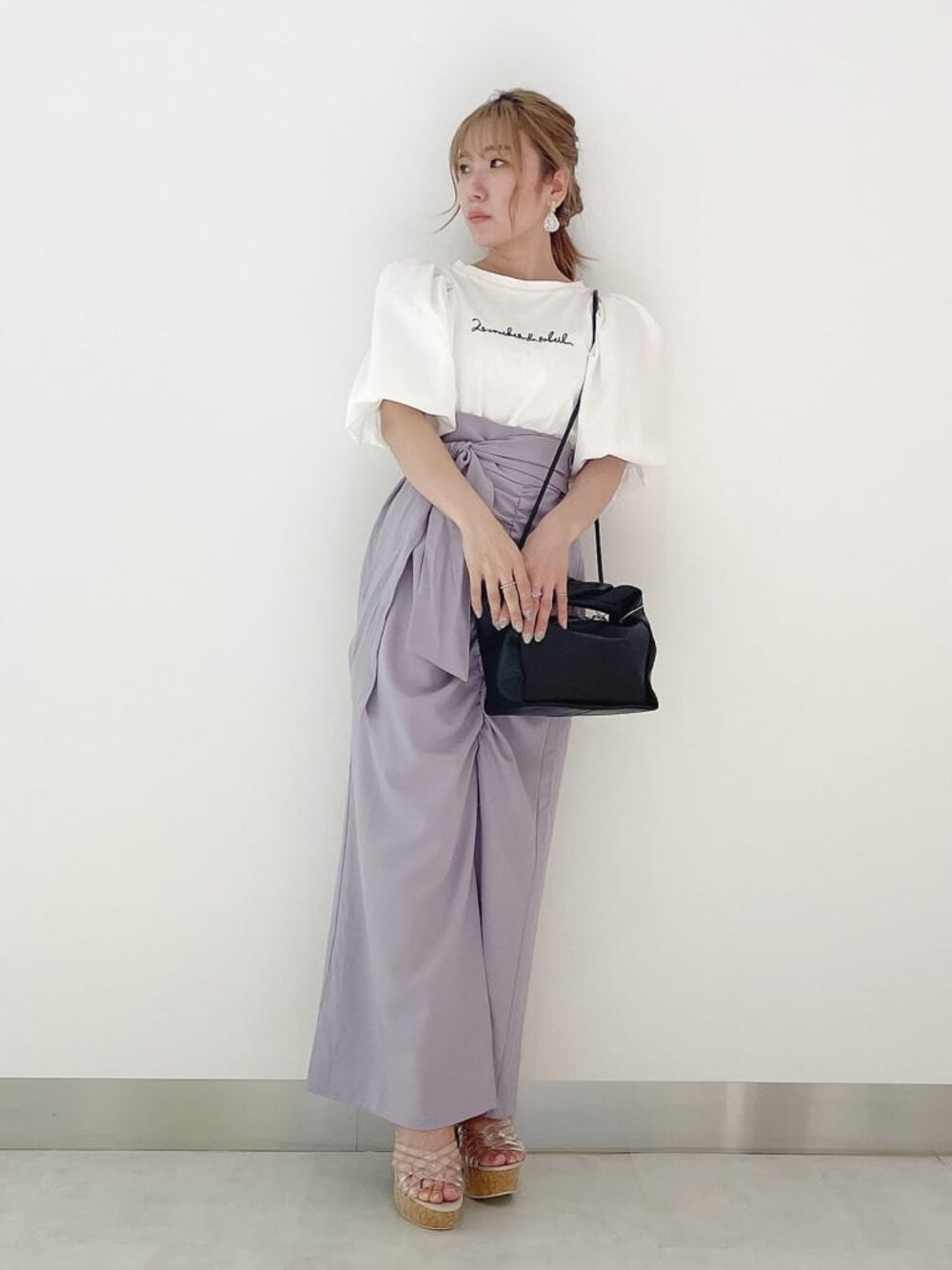 ブラック系のハンドバッグ、ホワイト系のTシャツ/カットソー、その他のサンダルを着用したレディースの夏コーディネートの1枚目の写真