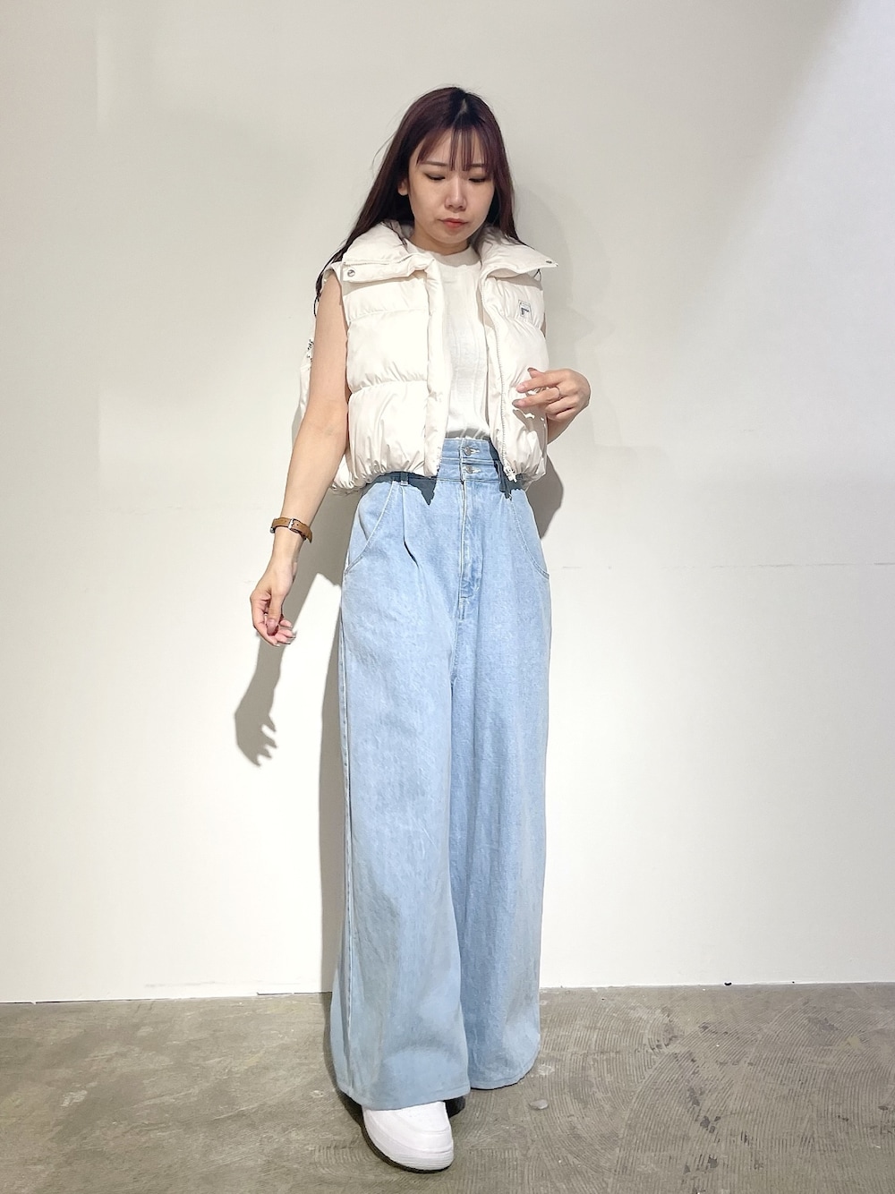 ブルー系のデニムパンツ、ホワイト系のニット/セーター、ホワイト系のベストを着用したレディースの夏コーディネートの1枚目の写真