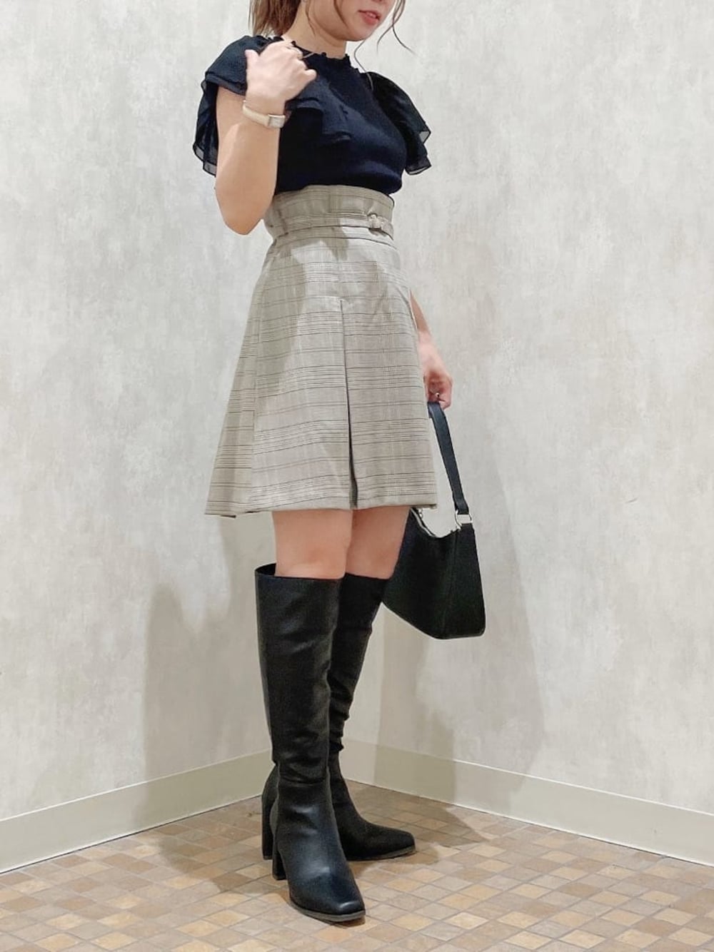 ブラック系のハンドバッグ、ブラック系のTシャツ/カットソー、グレー系のスカートを着用したレディースの夏コーディネートの1枚目の写真