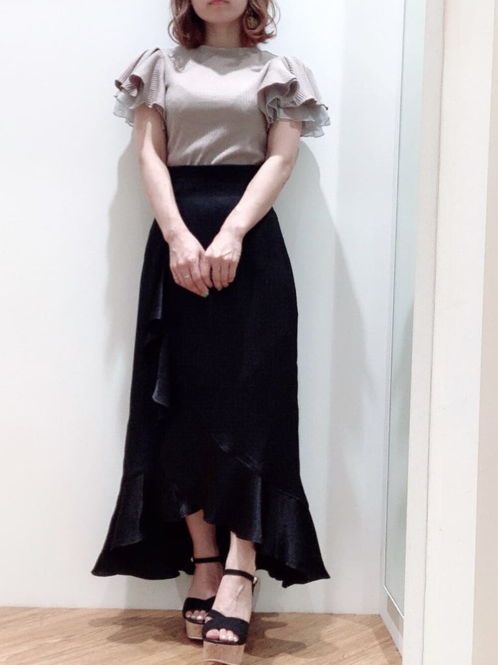ブラック系のスカート、ブラック系のサンダル、グレー系のTシャツ/カットソーを着用したレディースの夏コーディネートの1枚目の写真
