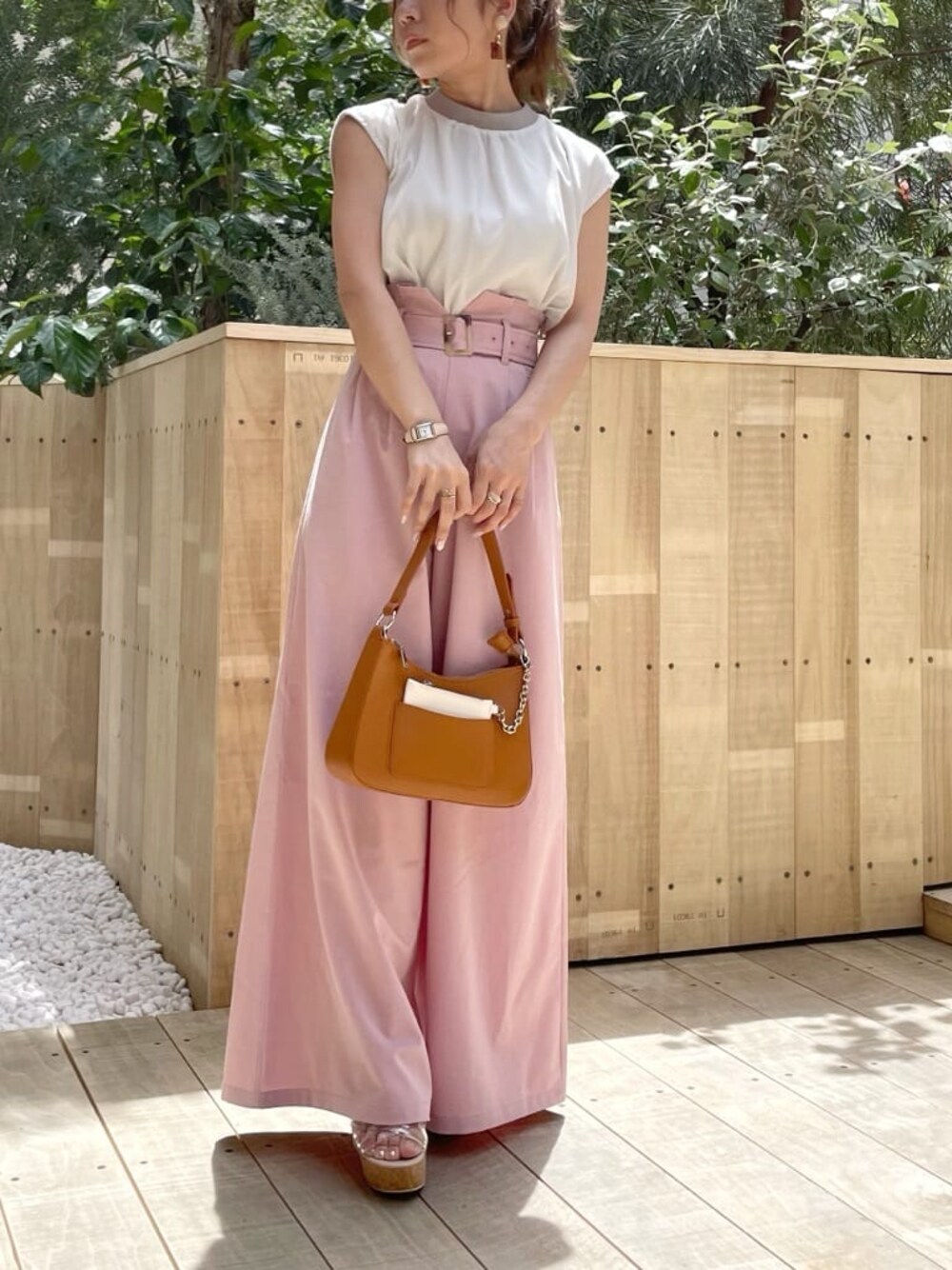 ブラウン系のハンドバッグ、その他のサンダル、ピンク系のその他パンツを着用したレディースの夏コーディネートの1枚目の写真