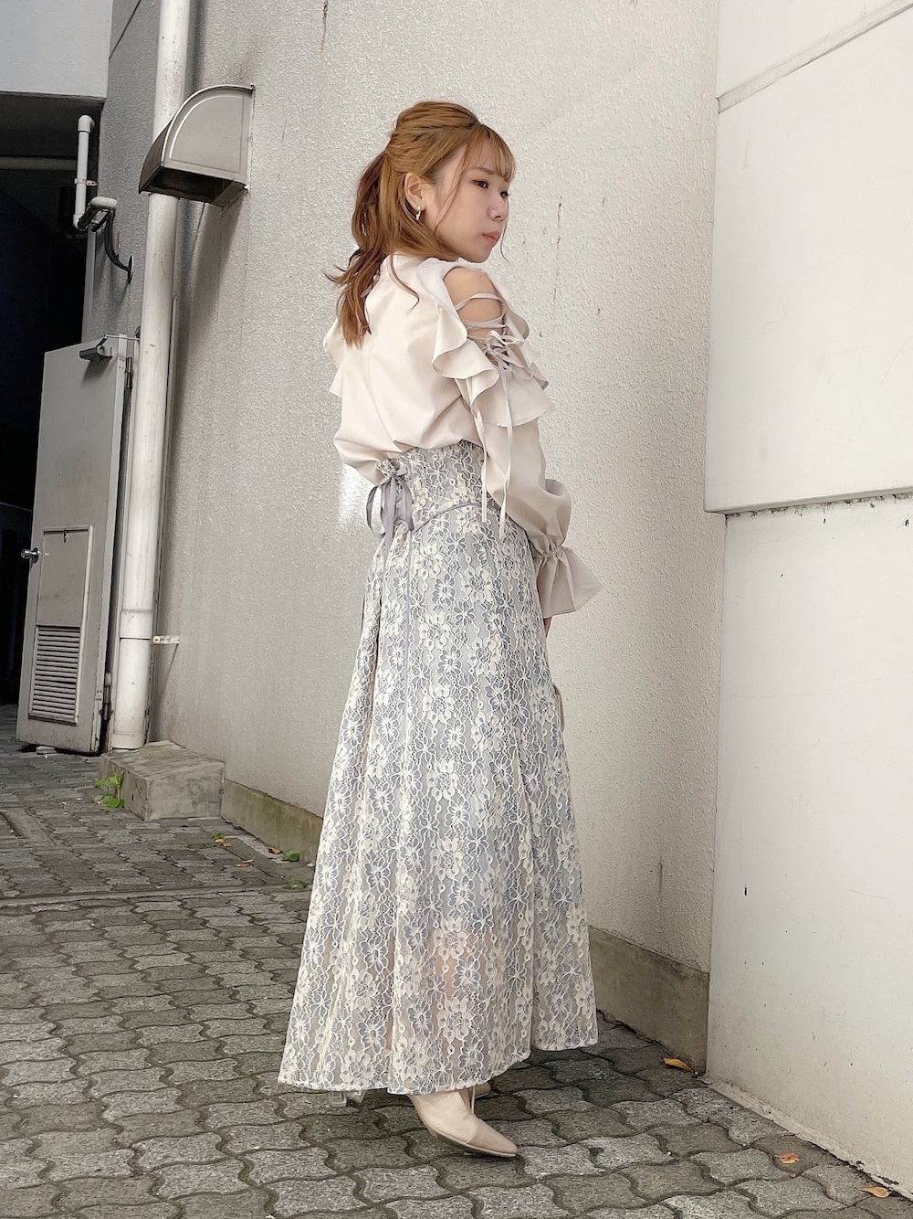 ベージュ系のシャツ/ブラウス、ブルー系のスカート、ホワイト系のパンプスを着用したレディースの冬コーディネートの1枚目の写真