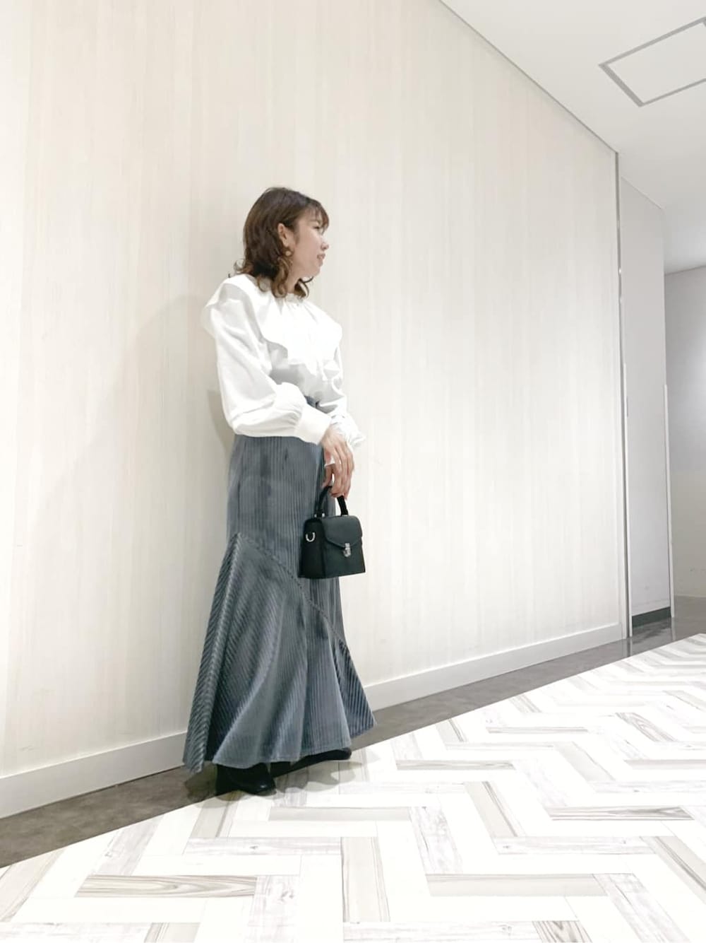 ホワイト系のシャツ/ブラウス、ブルー系のスカートを着用したレディースの秋コーディネートの1枚目の写真