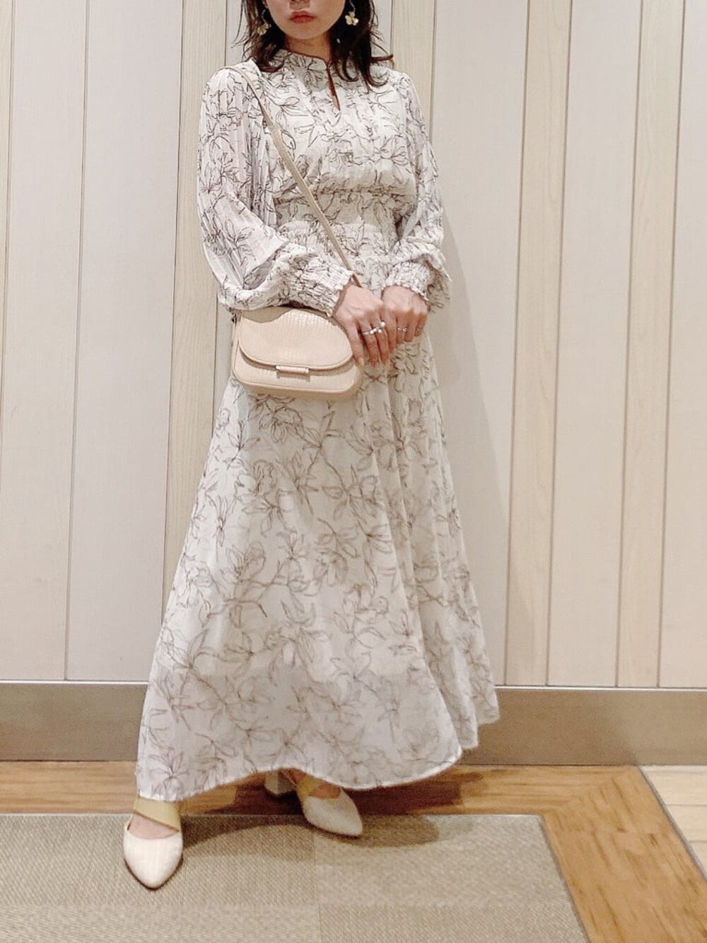 ホワイト系のワンピース、ベージュ系のパンプス、ベージュ系のショルダーバッグを着用したレディースの冬コーディネートの1枚目の写真