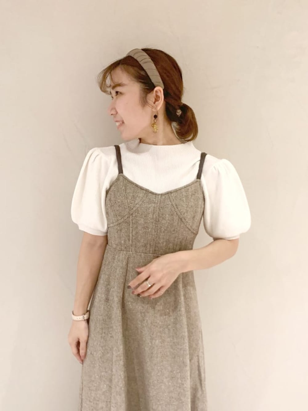 ブラウン系のワンピース、ホワイト系のパンプス、ホワイト系のニット/セーターを着用したレディースの秋コーディネートの1枚目の写真