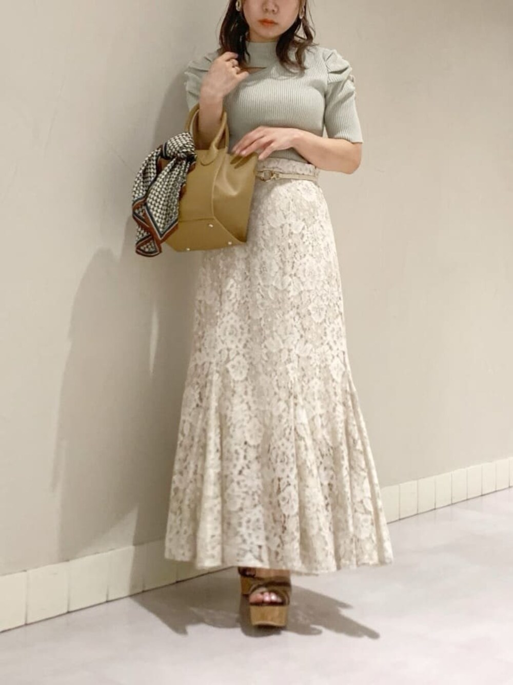 ベージュ系のハンドバッグ、その他のサンダル、グレー系のTシャツ/カットソーを着用したレディースの春コーディネートの1枚目の写真