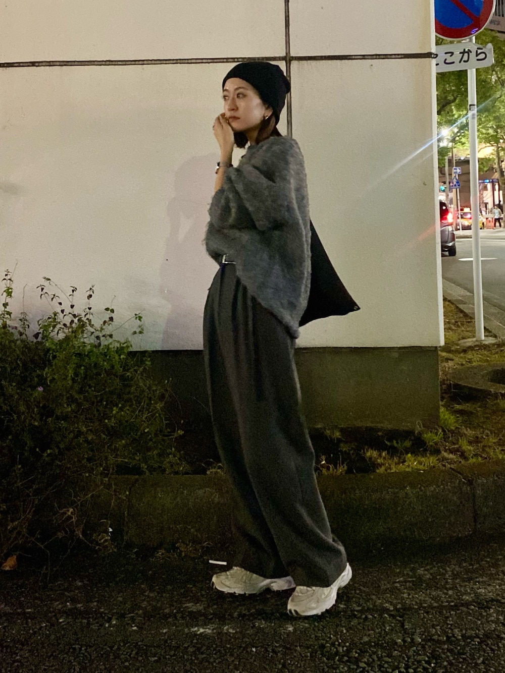グレー系のスラックス、グレー系のニット/セーターを着用したレディースの冬コーディネートの1枚目の写真