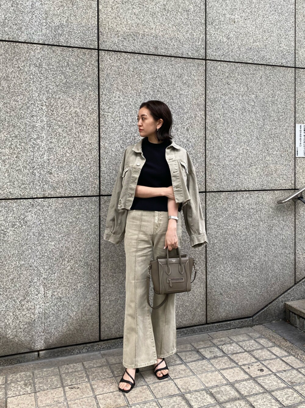 ベージュ系のデニムジャケット、ベージュ系のその他パンツ、ブラック系のサンダルを着用したレディースの春コーディネートの1枚目の写真