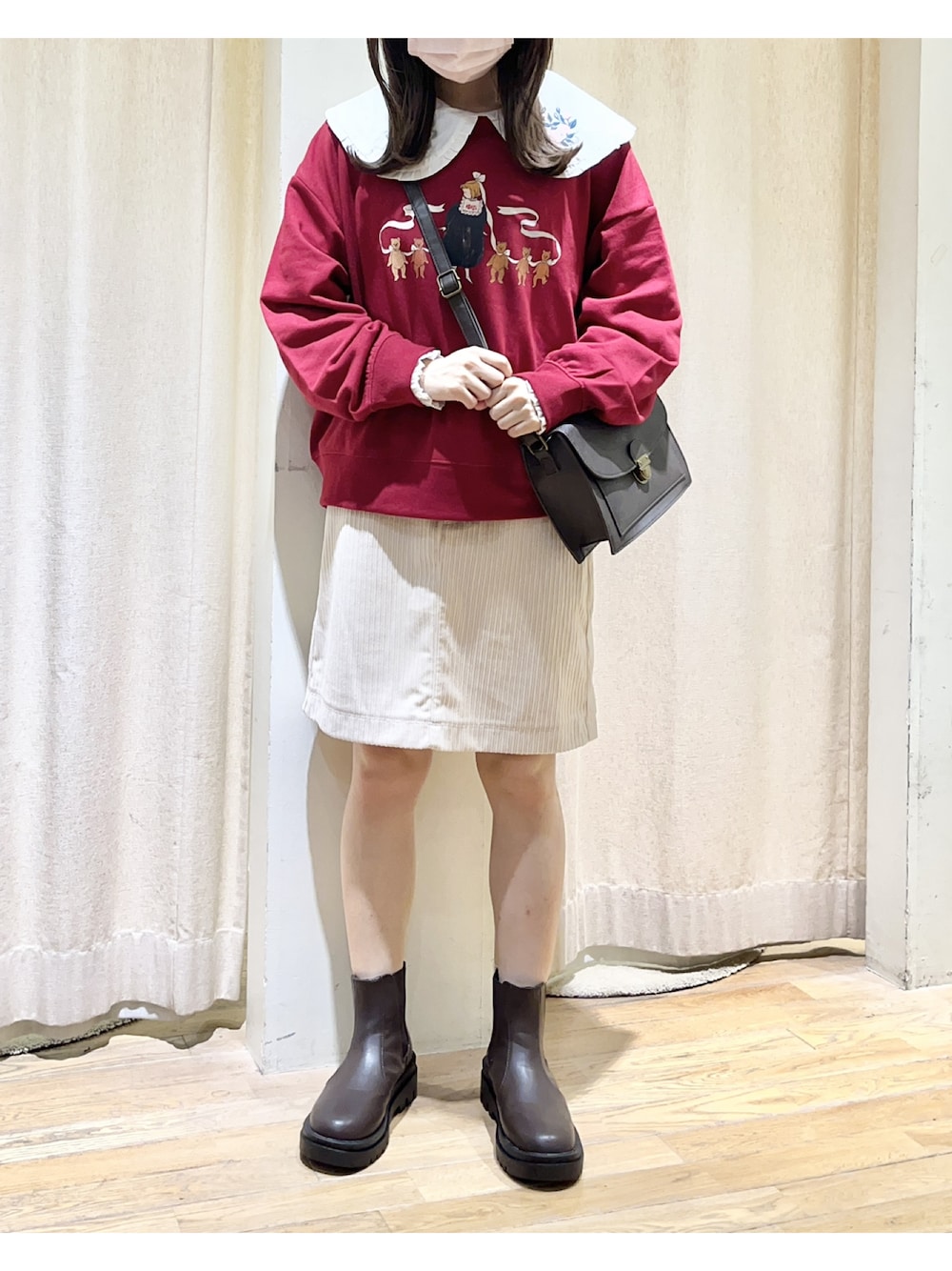 ホワイト系のスカート、ブラウン系のブーツ、ブラウン系のショルダーバッグを着用したレディースの秋コーディネートの1枚目の写真