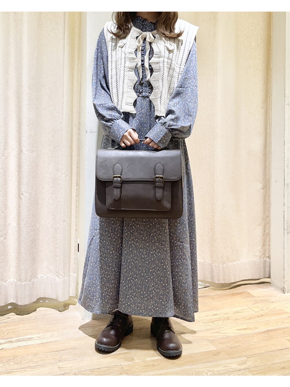 ブルー系のワンピース、ホワイト系のベスト、ブラウン系のその他シューズを着用したレディースの秋コーディネートの1枚目の写真