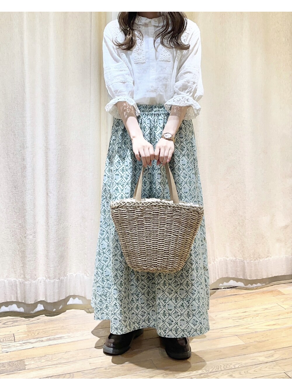 ホワイト系のシャツ/ブラウス、グリーン系のスカート、ベージュ系のハンドバッグを着用したレディースの春コーディネートの1枚目の写真