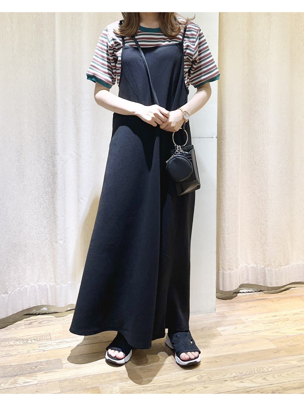 ブラック系のワンピース、ブラック系のサンダル、グリーン系のTシャツ/カットソーを着用したレディースの夏コーディネートの1枚目の写真