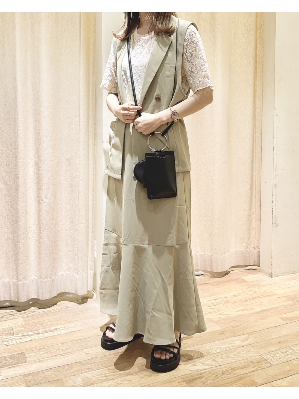 グリーン系のベスト、ホワイト系のTシャツ/カットソー、グリーン系のスカートを着用したレディースの夏コーディネートの1枚目の写真