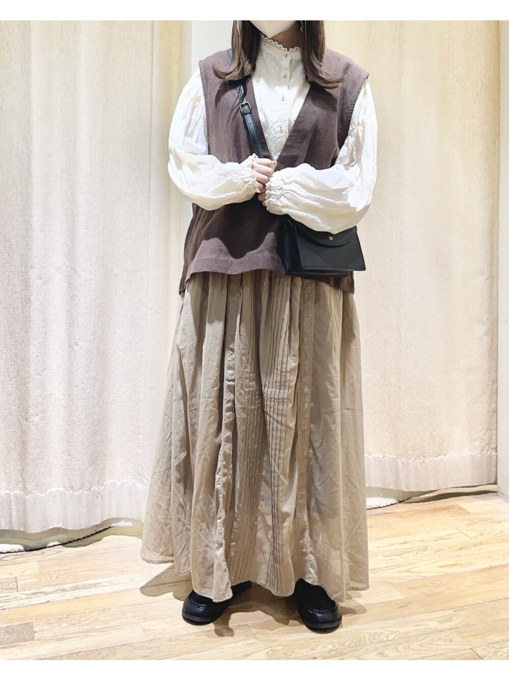 ホワイト系のシャツ/ブラウス、ブラウン系のベスト、ベージュ系のスカートを着用したレディースの夏コーディネートの1枚目の写真