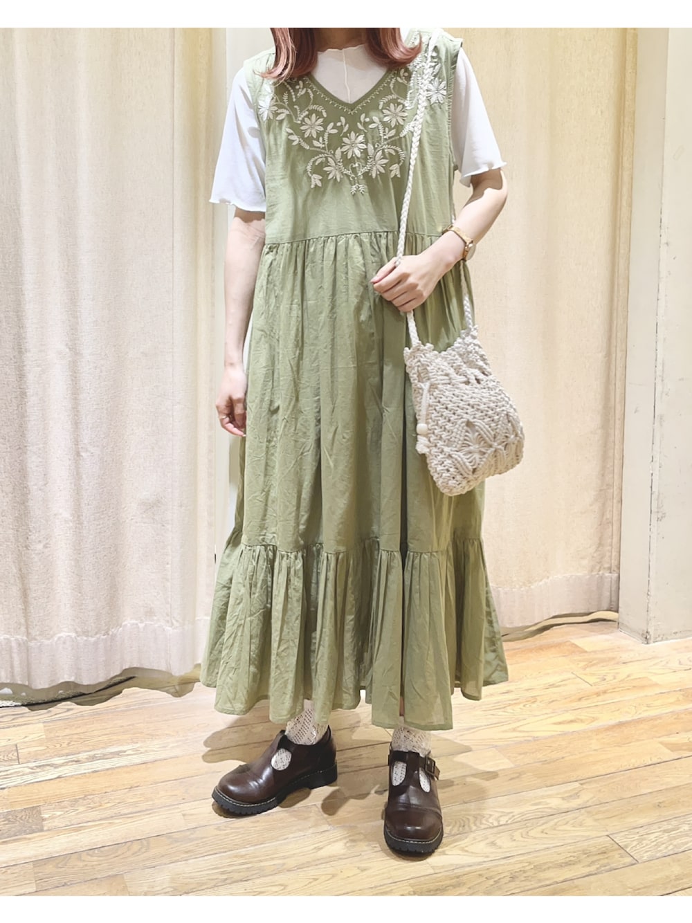 ホワイト系のニット/セーター、グリーン系のワンピース、ブラウン系のドレスシューズを着用したレディースの夏コーディネートの1枚目の写真