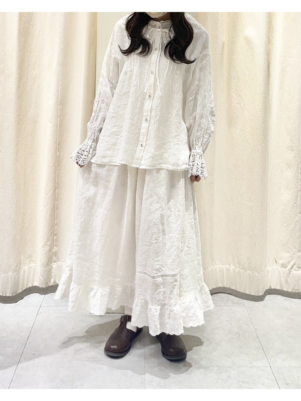 ホワイト系のシャツ/ブラウス、ホワイト系のスカート、ブラウン系のドレスシューズを着用したレディースの秋コーディネートの1枚目の写真