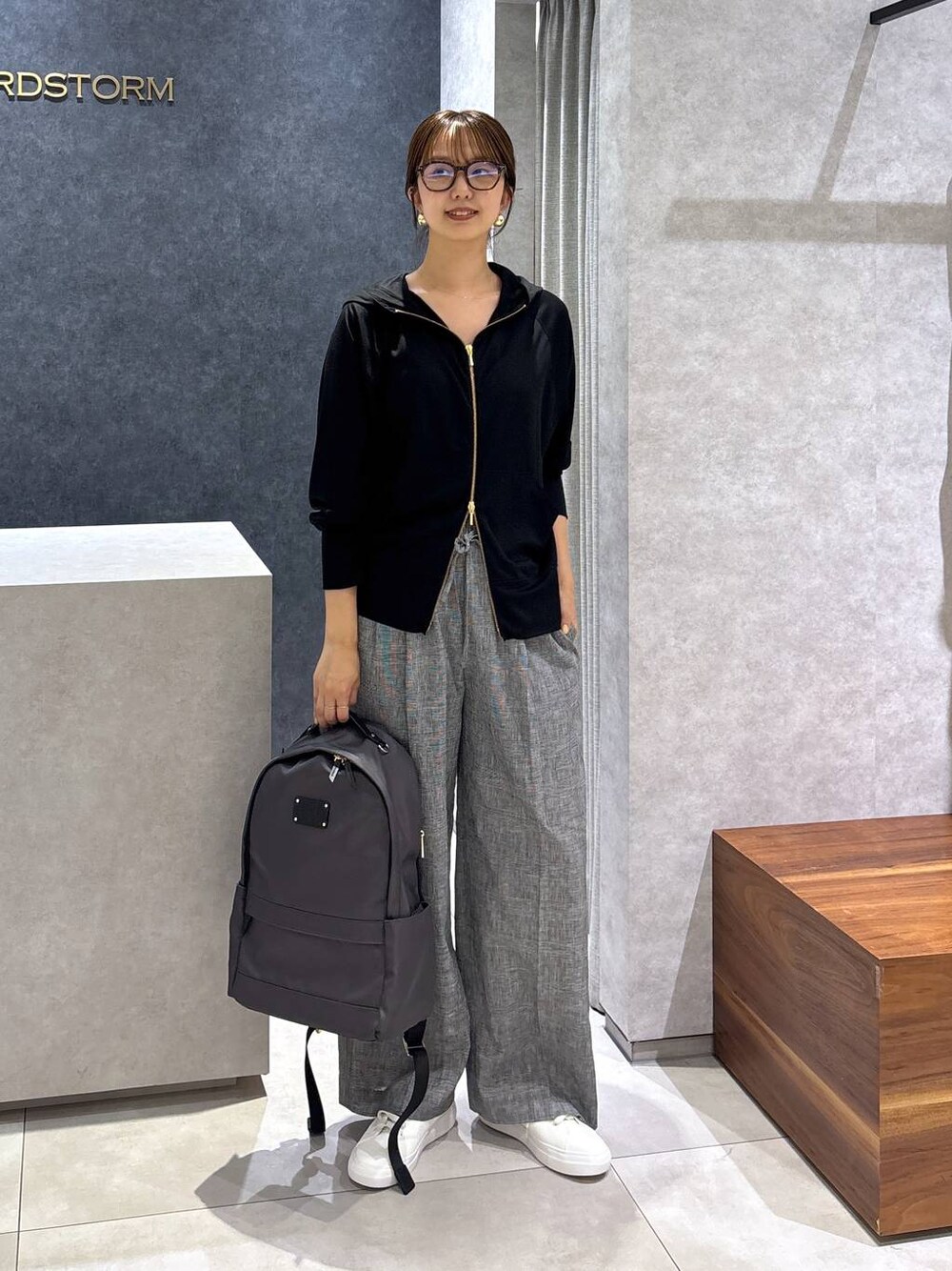 グレー系のバックパック/リュック、ホワイト系のスニーカー、グレー系のその他パンツを着用したレディースの夏コーディネートの1枚目の写真