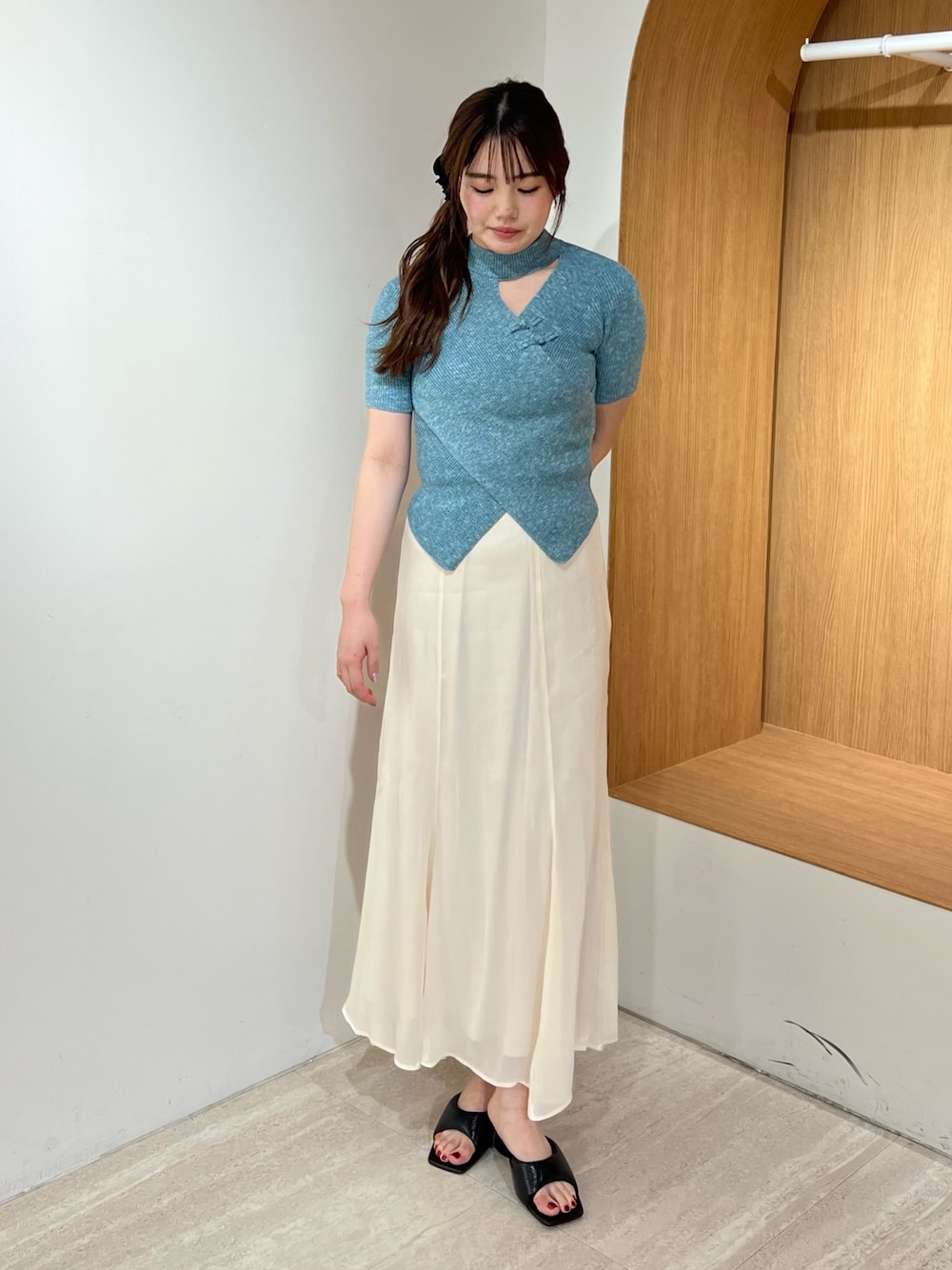 ブラック系のパンプス、ホワイト系のスカート、ブルー系のニット/セーターを着用したレディースの夏コーディネートの1枚目の写真