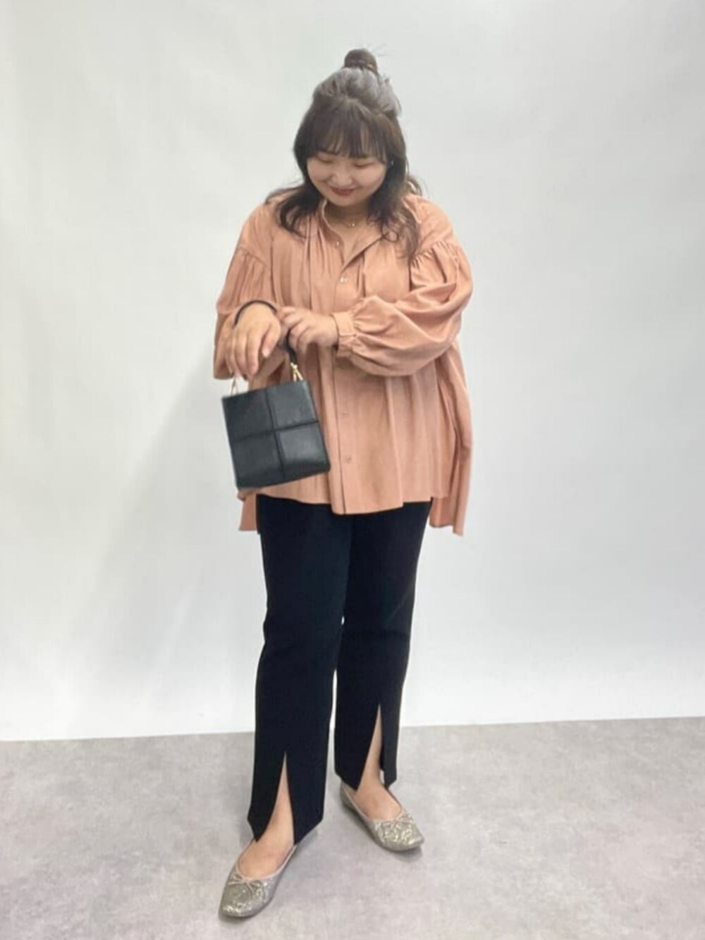 ブラック系のハンドバッグ、ゴールド系のパンプス、ピンク系のシャツ/ブラウスを着用したレディースの秋コーディネートの1枚目の写真