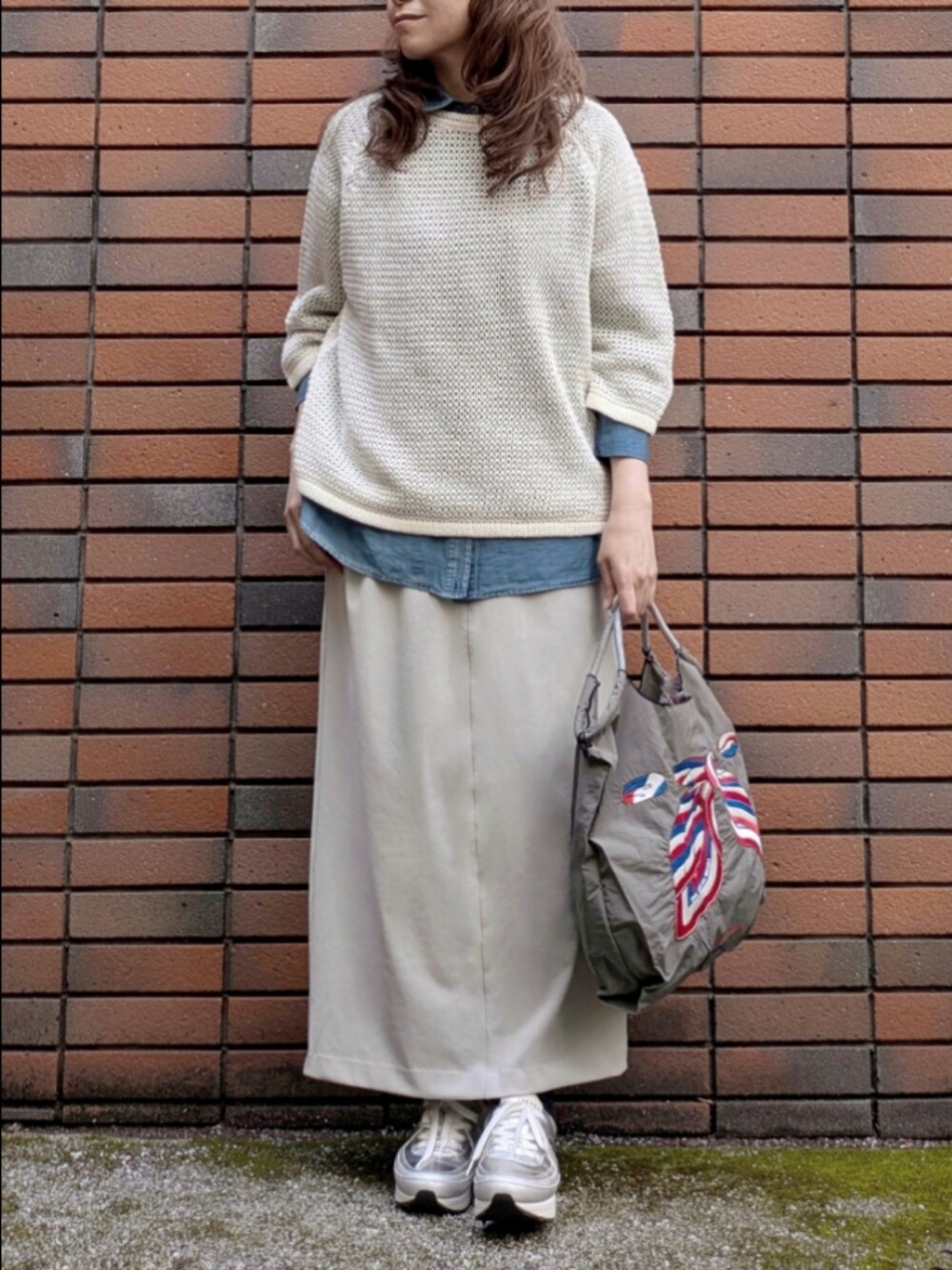 ブルー系のシャツ/ブラウス、ホワイト系のニット/セーターを着用したレディースの春コーディネートの1枚目の写真