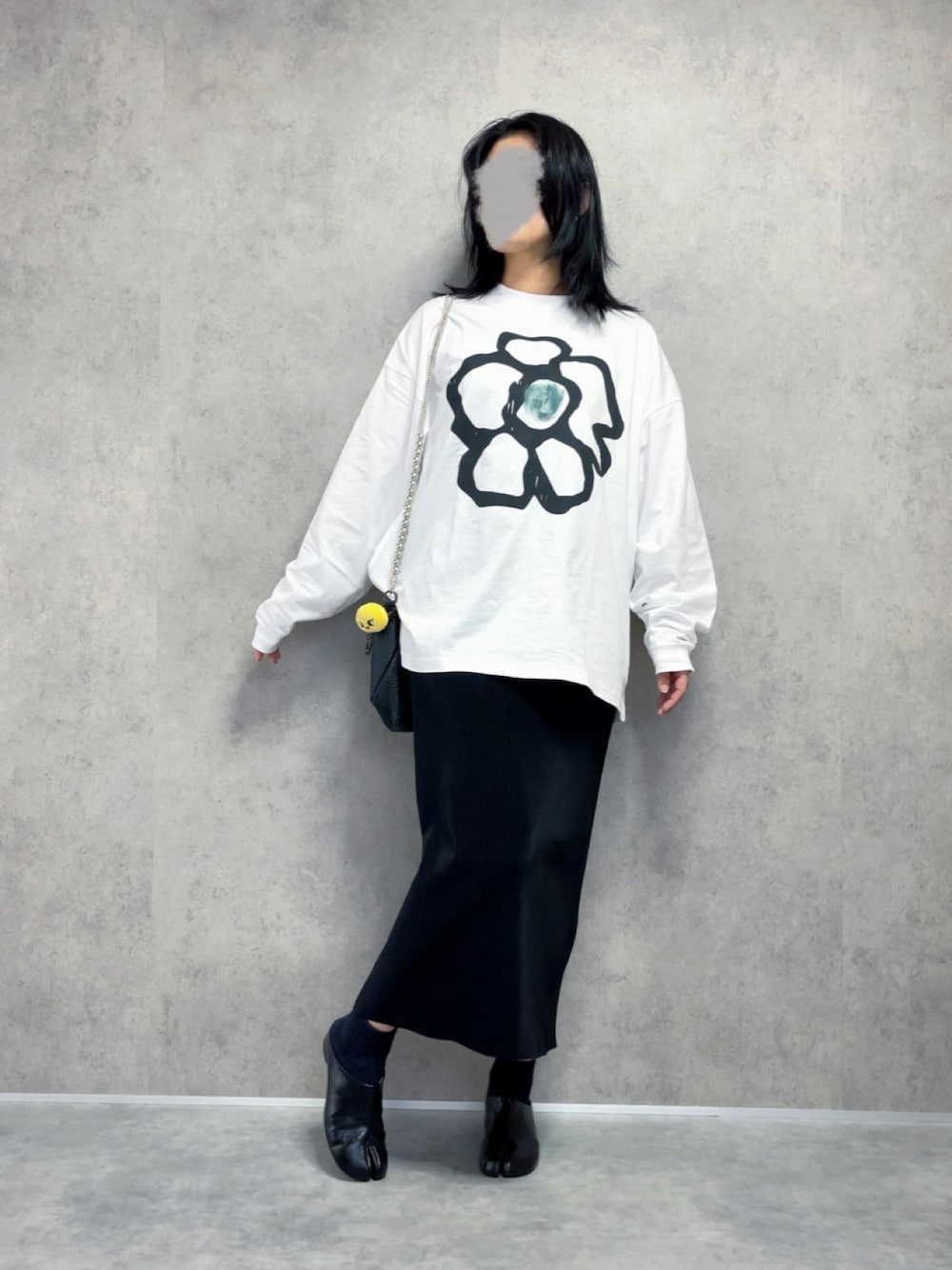 ホワイト系のTシャツ/カットソー、ブラック系のスカート、ブラック系のスリッポンを着用したレディースの秋コーディネートの1枚目の写真