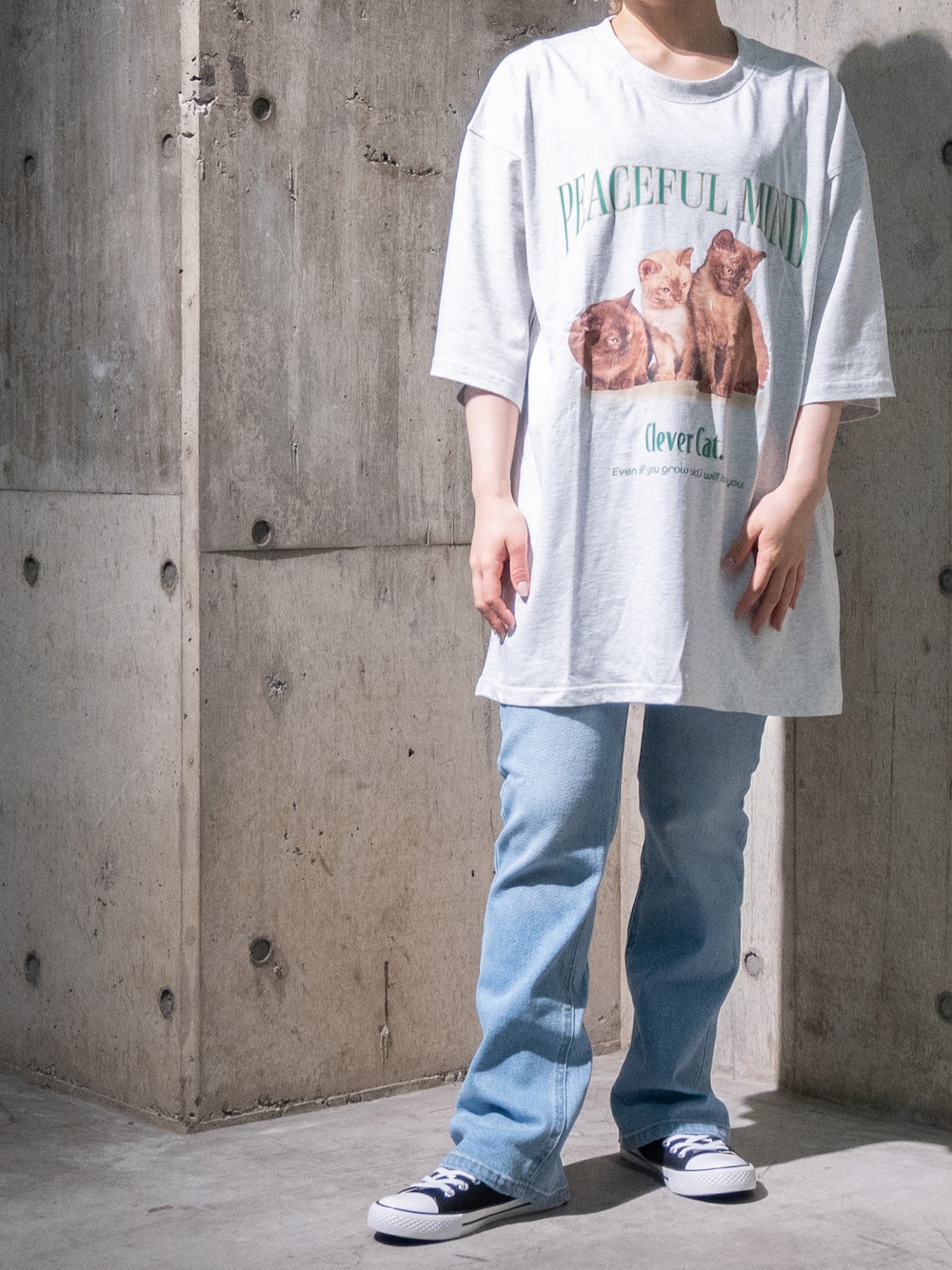 グレー系のTシャツ/カットソー、ブルー系のデニムパンツを着用したレディースの春コーディネートの1枚目の写真