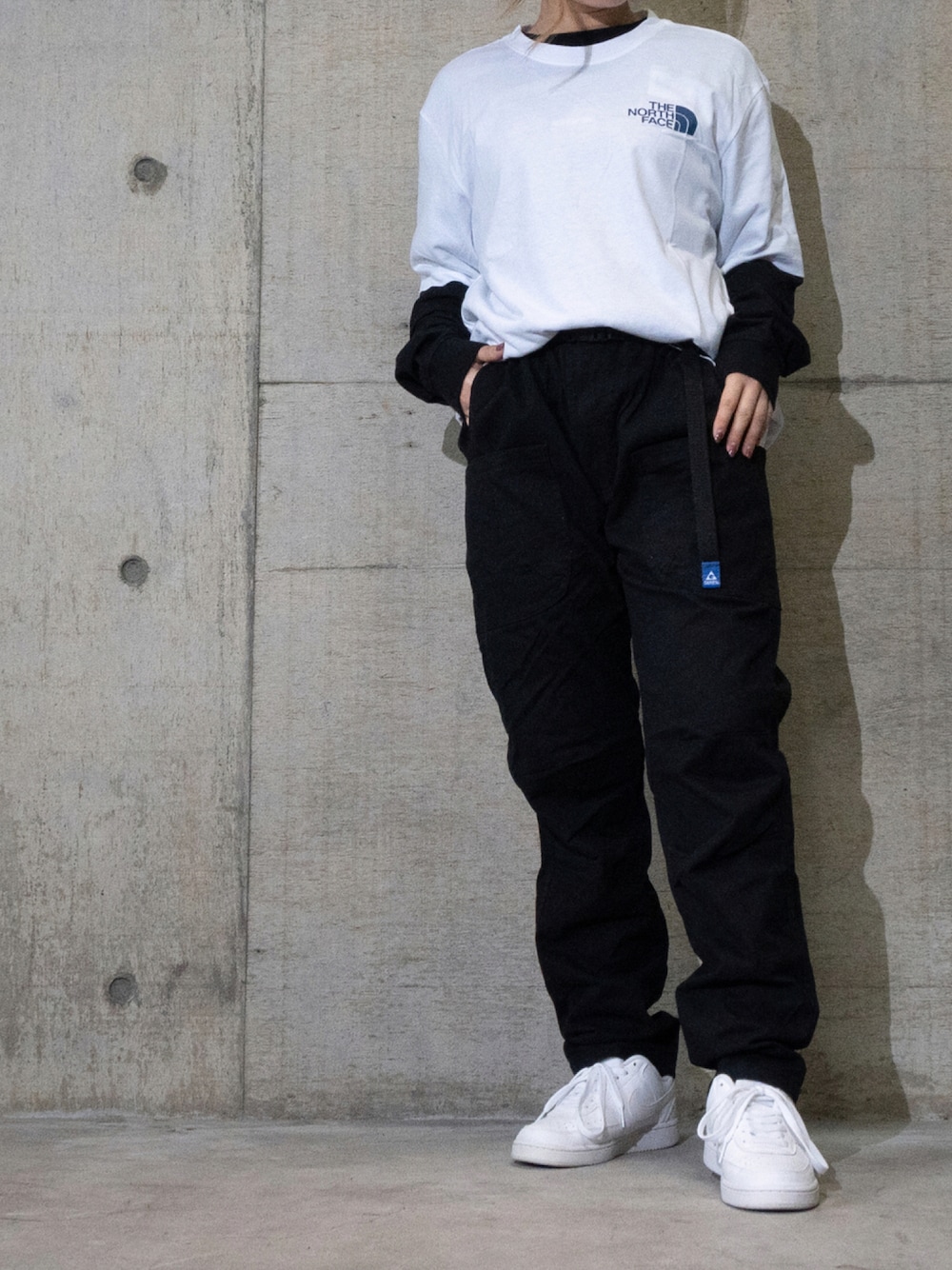 ホワイト系のTシャツ/カットソー、ブラック系のTシャツ/カットソー、ブラック系のデニムパンツを着用したレディースの秋コーディネートの1枚目の写真