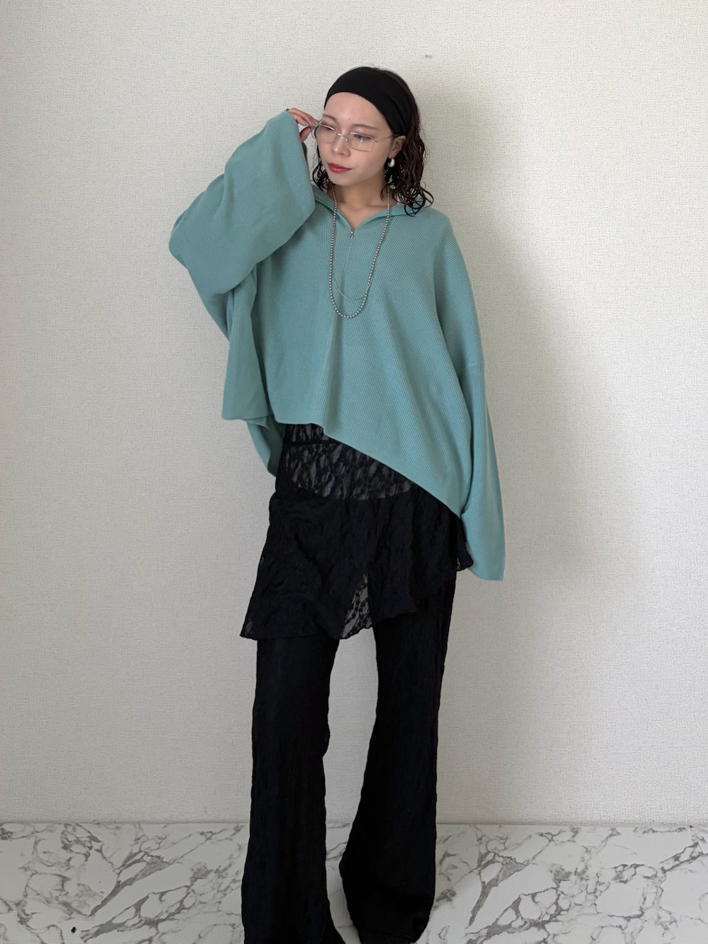 ブルー系のニット/セーター、ブラック系のその他パンツ、ホワイト系のTシャツ/カットソーを着用したレディースの春コーディネートの1枚目の写真