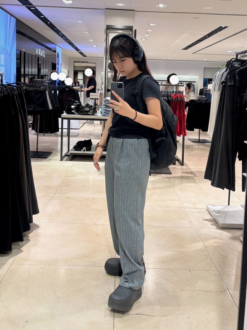 ブラック系のバックパック/リュック、ブラック系のスリッポン、ブラック系のTシャツ/カットソーを着用したレディースの秋コーディネートの1枚目の写真